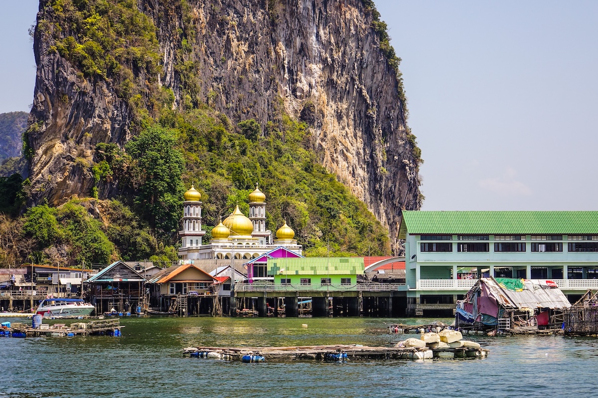 Koh Panyee floating village beneath limestone cliffs in Phang Nga Bay